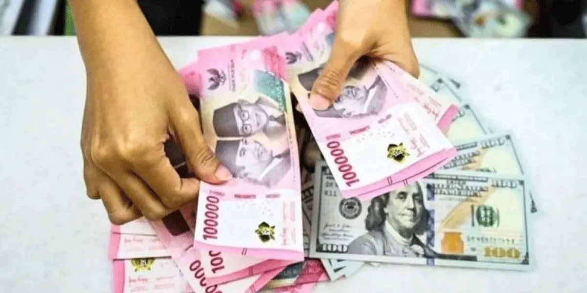 Ilustrasi - Petugas menghitung uang pecahan rupiah dan USD di gerai penukaran mata uang asing di Jakarta, awal Januari 2025 lalu.