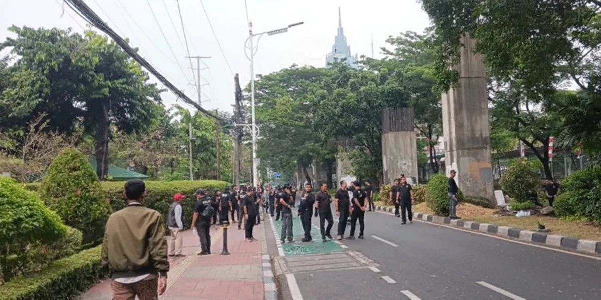 Sejumlah polisi berpakaian preman berjaga di belakang gedung DPR untuk mencegah penyusup.