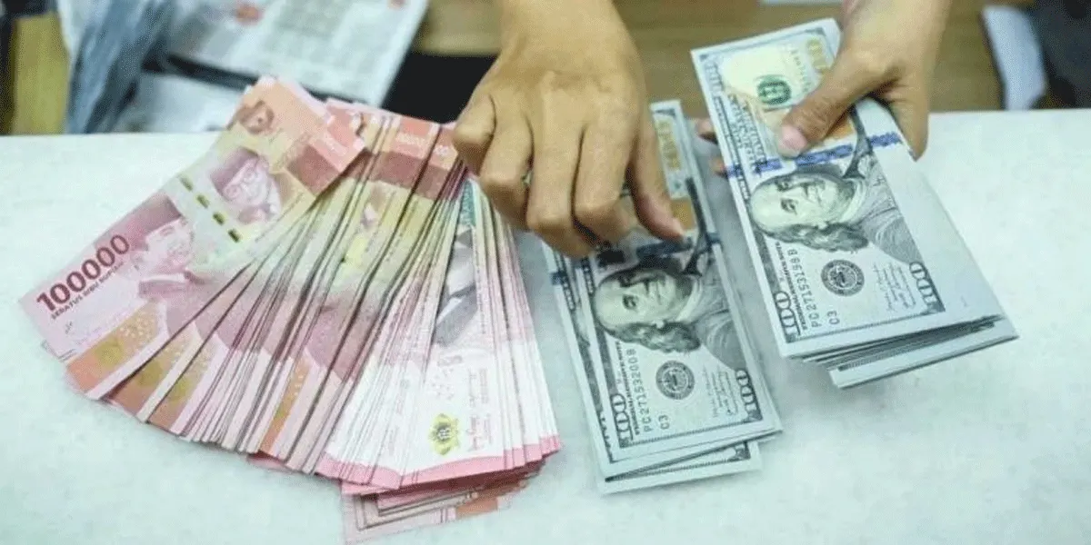 Ilustrasi petugas menghitung uang pecahan dolar AS dan rupiah di gerai penukaran mata uang asing di Jakarta akhir April 2024 lalu.