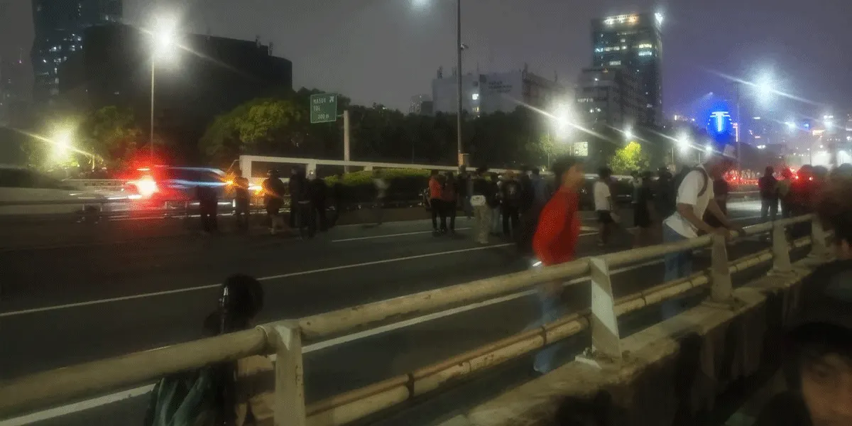 Sejumlah orang terlihat berlarian ke jalan tol dalam kota saat demonstrasi berujung ricuh di depan Gedung DPR, Jalan Gatot Subroto, Jakarta Pusat, Kamis (27/8/2026).