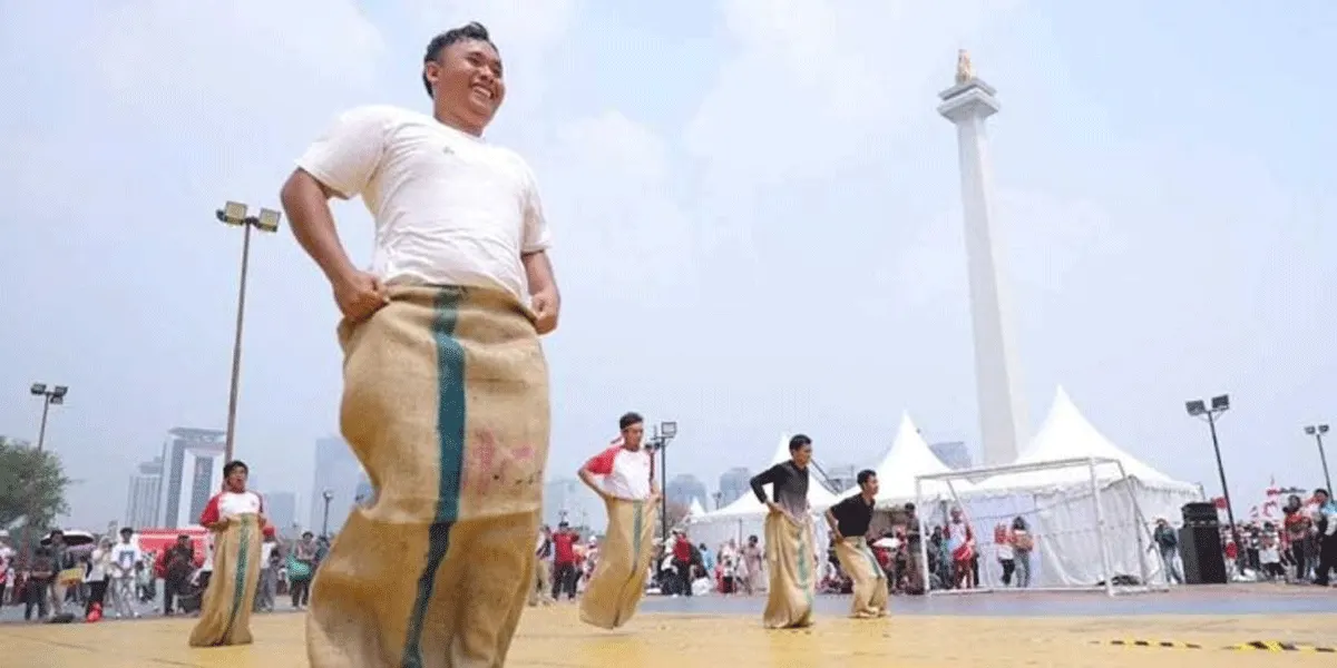 Ilustrasi - Peserta mengikuti lomba balap karung dalam peringatan Hari Kemerdekaan di kawasan Monas, Jakarta pada 17 Agustus 2026 di tengah cuaca yang terik. Pemprov DKI menyiagakan 1.027 personel dan 29 mobil tangki untuk mengantisipasi dampak puncak musim kemarau.